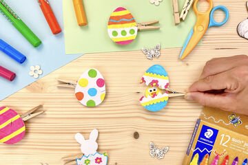 Idée DIY de Pâques pour les enfants : bricoler des œufs de Pâques colorés collés sur des pinces à linge