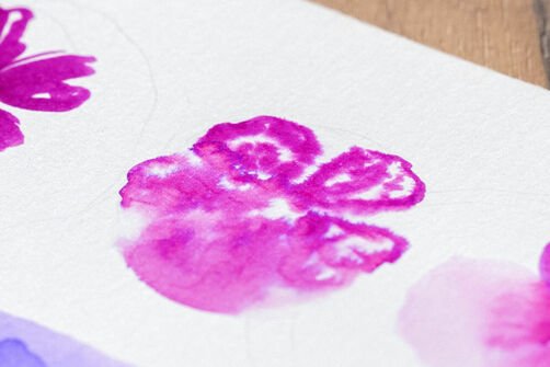Watercolour technique with watercolour brush pens "dry-on-wet": Pink drawn flower with colour running at the bottom, on white watercolour paper