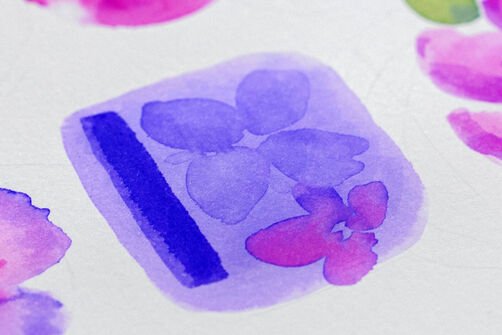 Watercolour technique with watercolour brush pens "Layering": A dark blue line and a purple and pink flower in a purple field on white watercolour paper